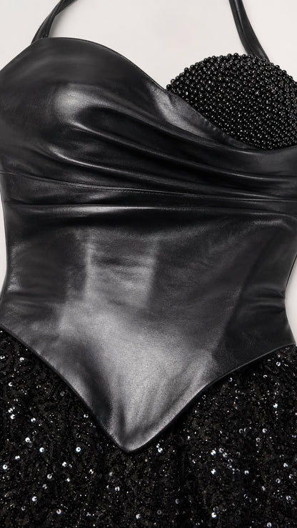 Close-up detail of smooth faux leather bodice and textured sequin skirt
