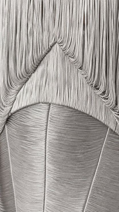 Close-up detail of textured layered fringe construction on dress bodice