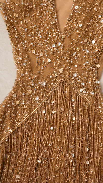 Close-up detail shot of the bodice beadwork, sequins, and fringe