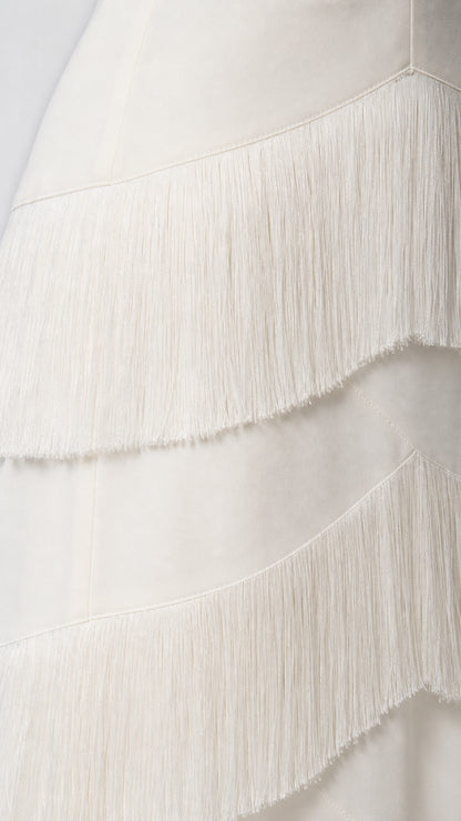 Close-up detail of the fringe texture on the white dress