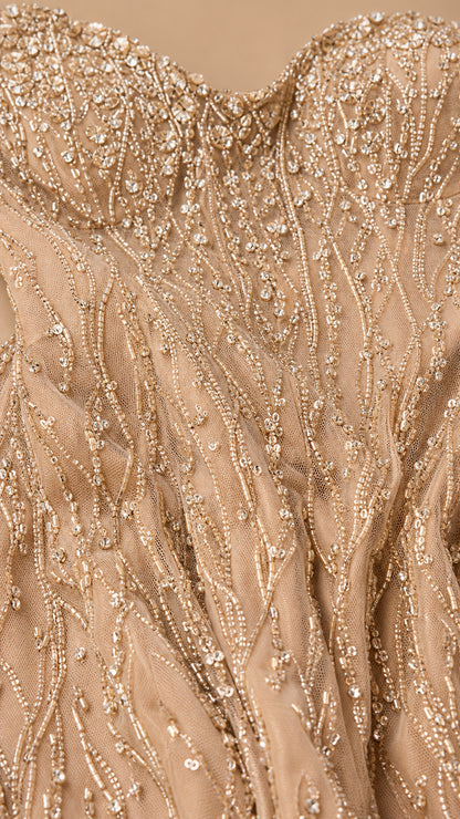 Close-up detail of champagne mesh fabric with intricate sequin and bead embroidery