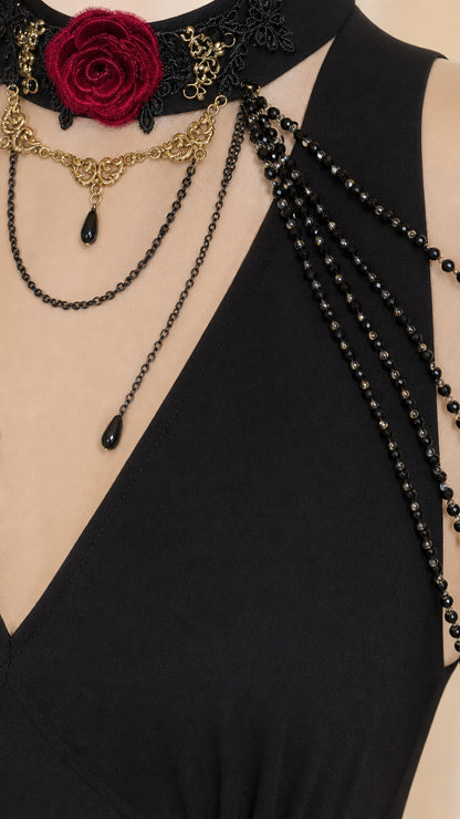Close-up of neckline showing black lace choker, red rose accent, and draped chains