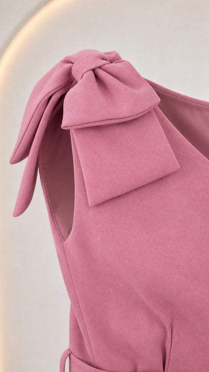 Close-up detail of the shoulder bow on the pink dress