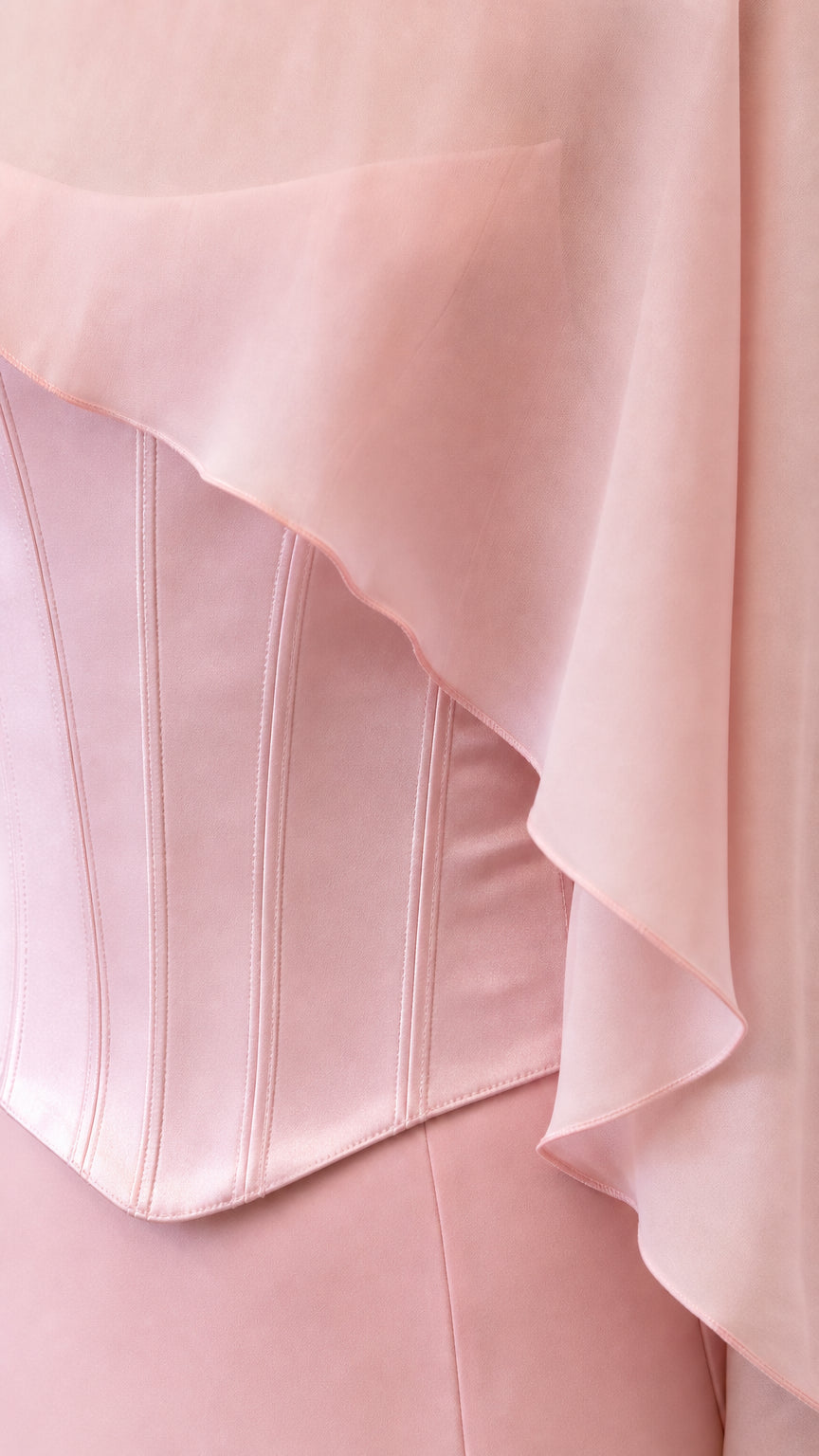 Close-up of structured corset bodice and sheer cape overlay in pink