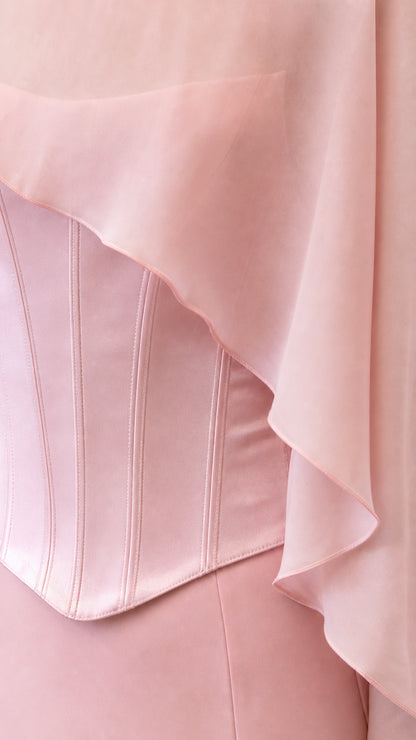 Close-up of structured corset bodice and sheer cape overlay in pink