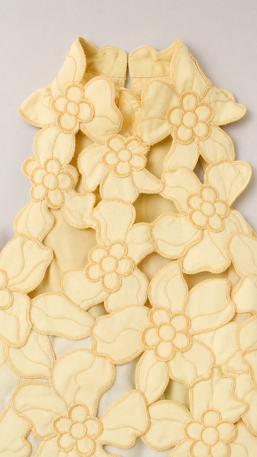 Close-up detail of Yellow floral laser-cut fabric pattern