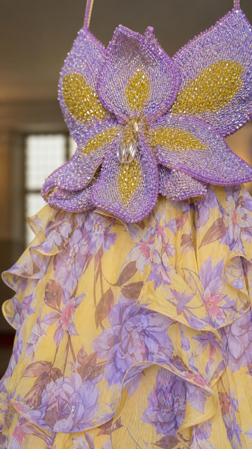 Close-up of intricate beaded flower bodice and floral fabric