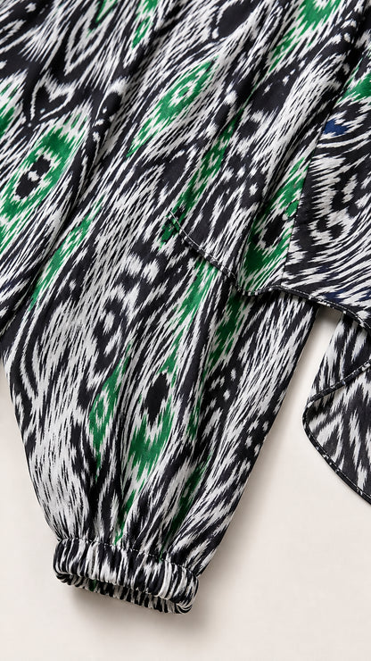 Close-up detail of gathered elastic sleeve cuff on black, white, and green Ikat print fabric