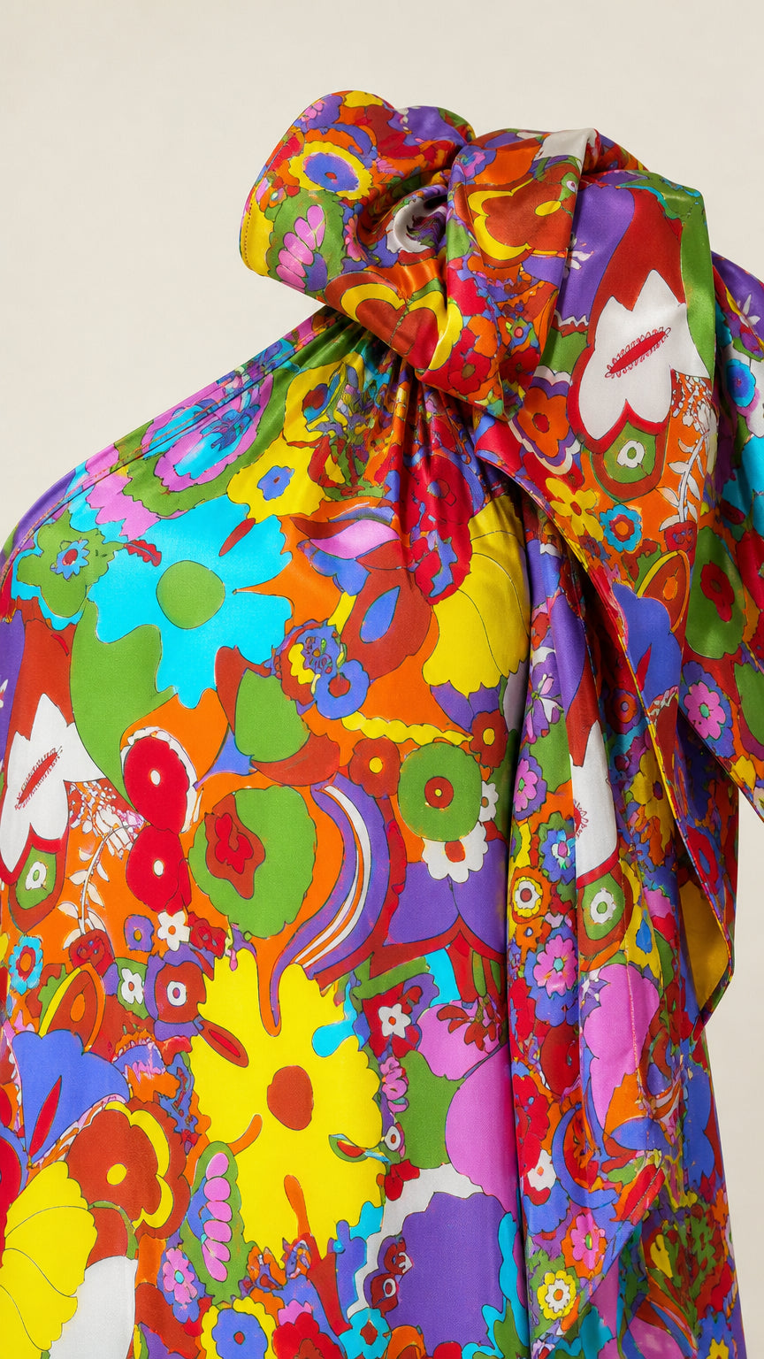 Close-up of vibrant floral fabric pattern and oversized shoulder bow