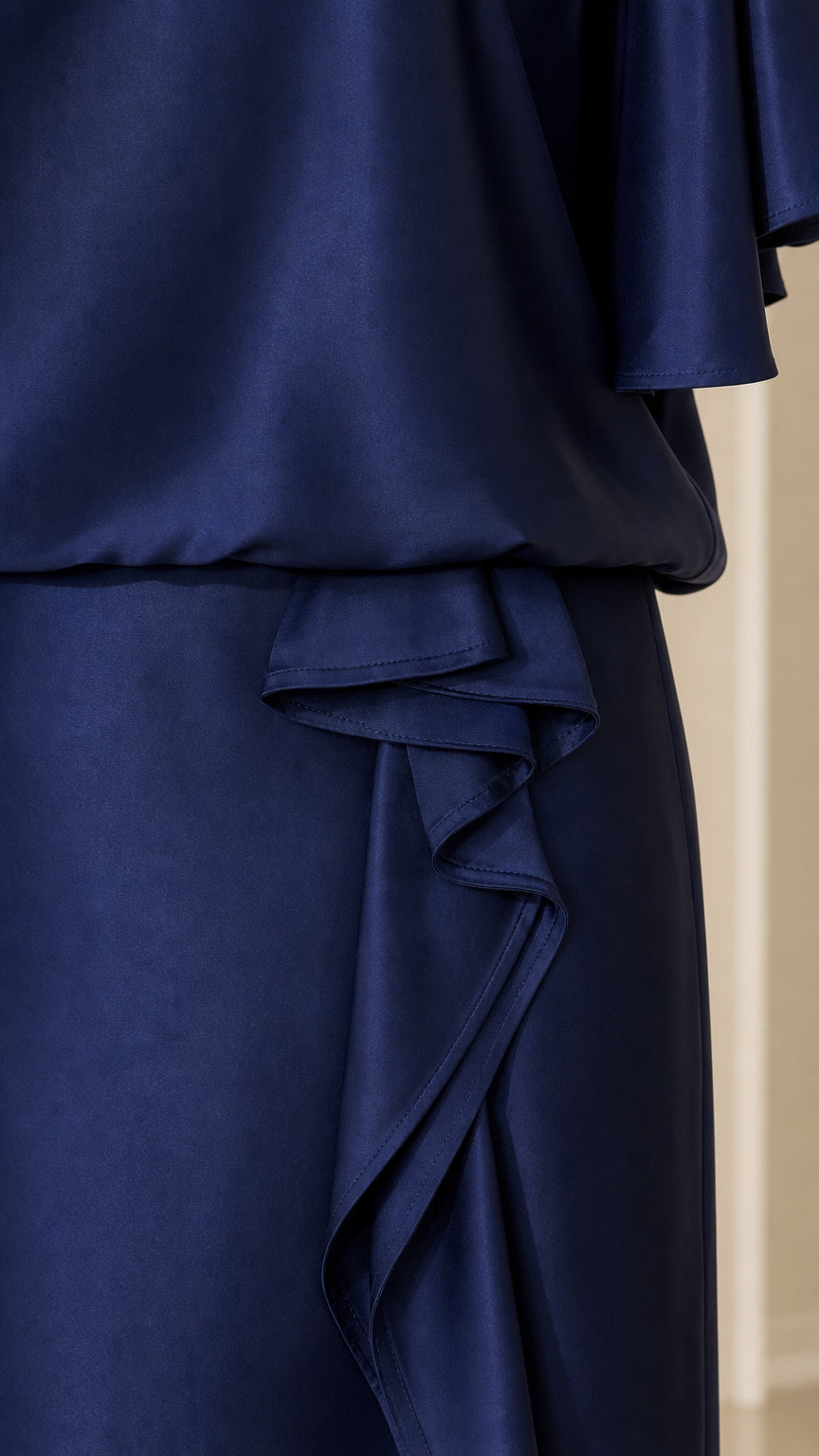 Close-up detail of cascading ruffle and satin fabric in navy blue