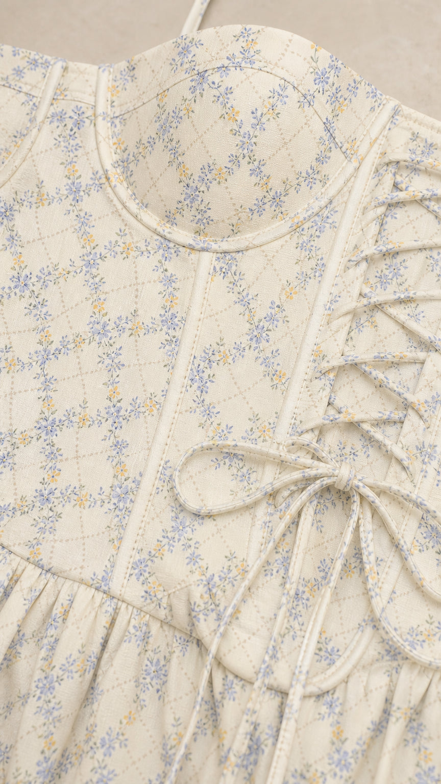 Close-up detail of bodice and lace-up side tie on white floral dress