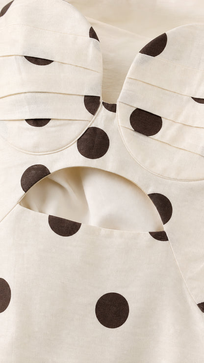 Close-up detail of structured sweetheart bodice and cutout on cream polka dot dress