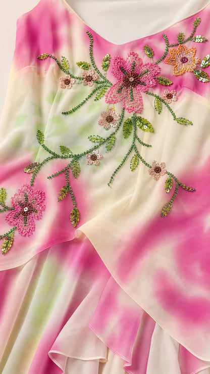 Close-up detail of delicate pink and green beaded floral embroidery on dress bodice