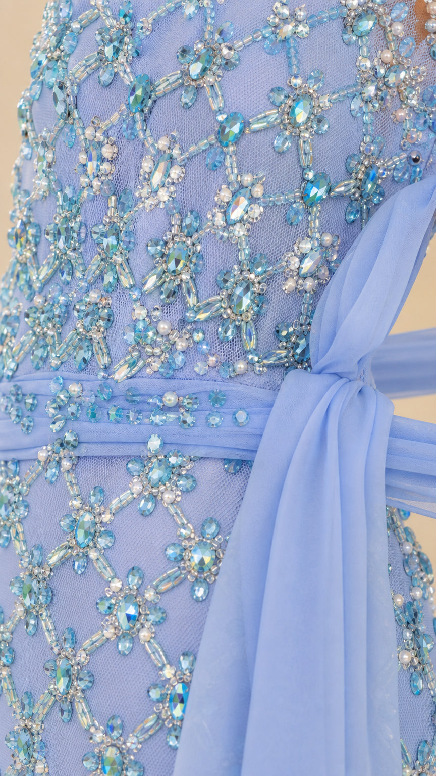 Close-up detail of rhinestone beadwork and chiffon wrap on dress