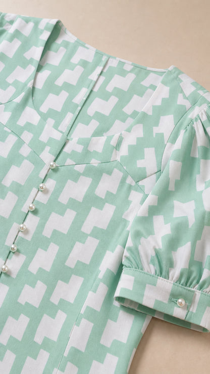 Close-up of sweetheart neckline and button details on mint green dress