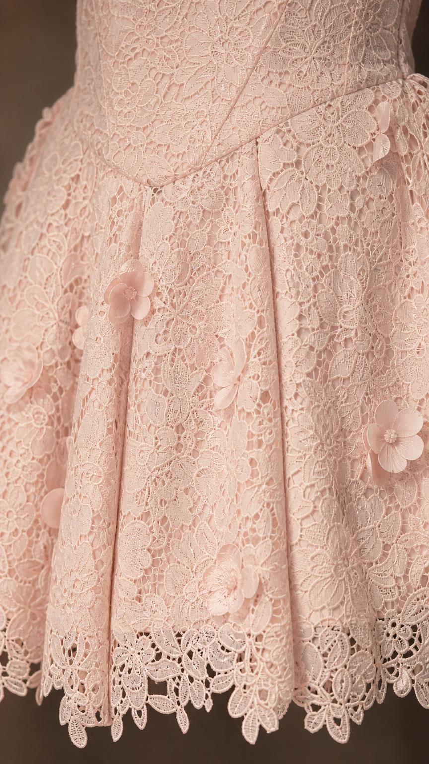 Close-up detail of lace pattern and floral appliques on skirt