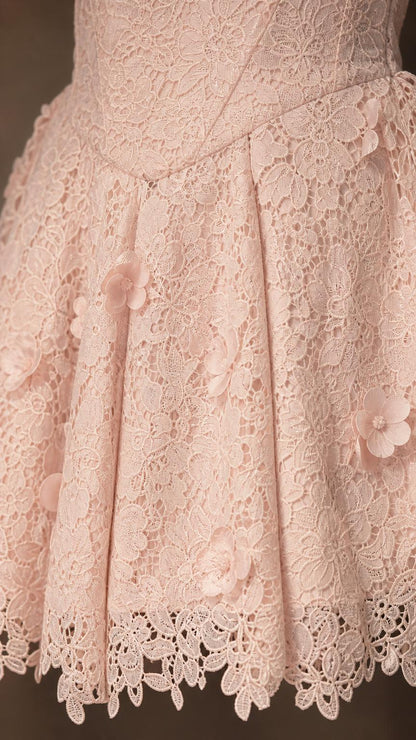 Close-up detail of lace pattern and floral appliques on skirt
