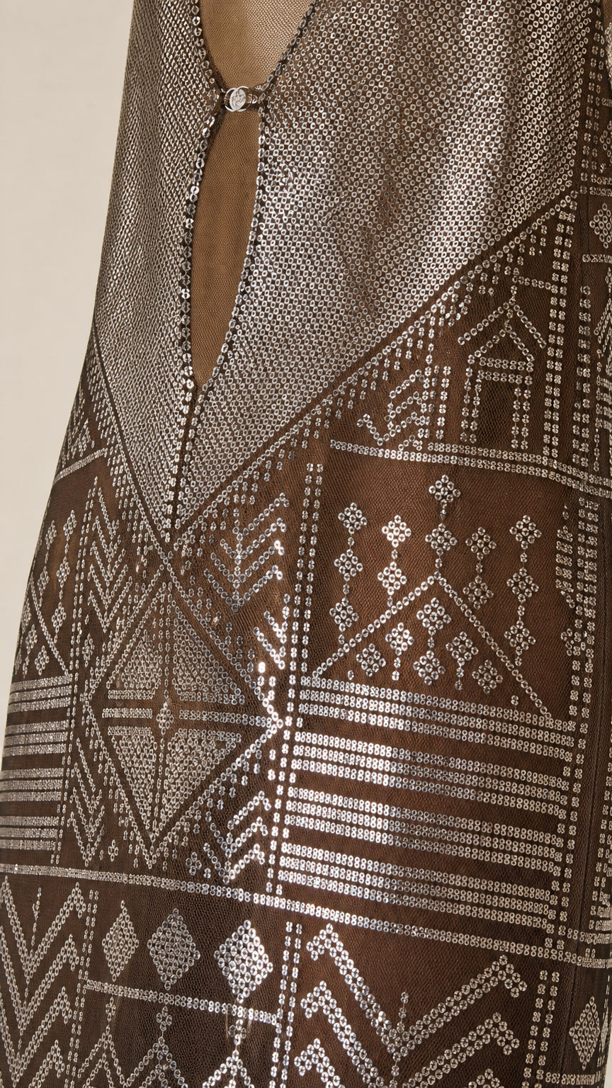 Close-up detail of the metallic geometric pattern and hardware on the dress