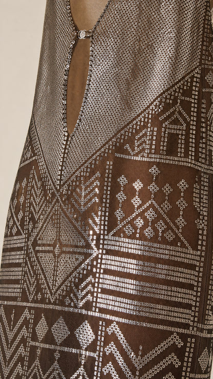 Close-up detail of the metallic geometric pattern and hardware on the dress