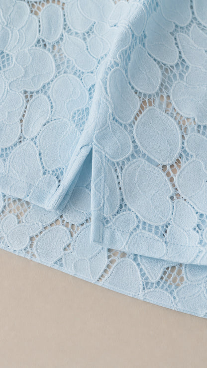 Close up of light blue floral lace fabric texture and side slit detail