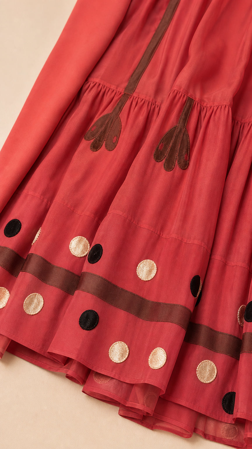 Close-up of tiered skirt hemline with floral embroidery and polka dot details