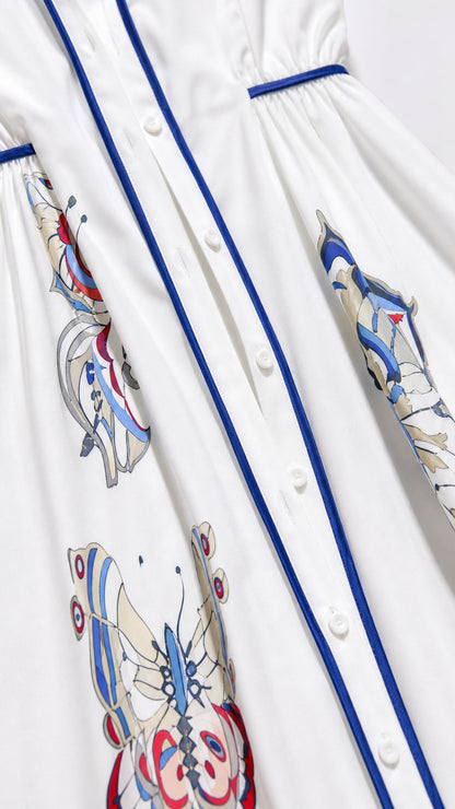 Close-up detail of button placket and butterfly print on white dress