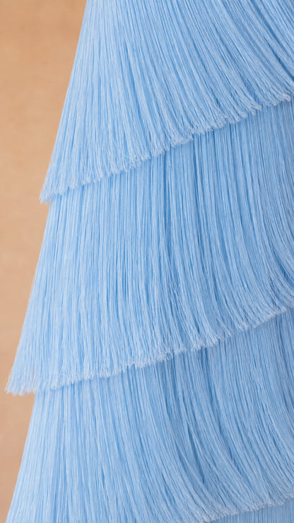 Close-up detail of textured sky blue fringe layers on strapless maxi gown
