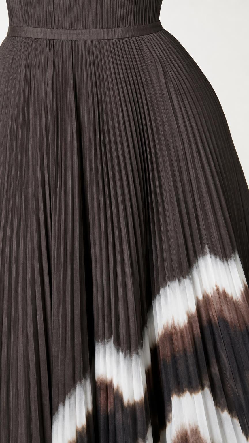 Close-up detail of pleated texture and dip-dye hem on dress