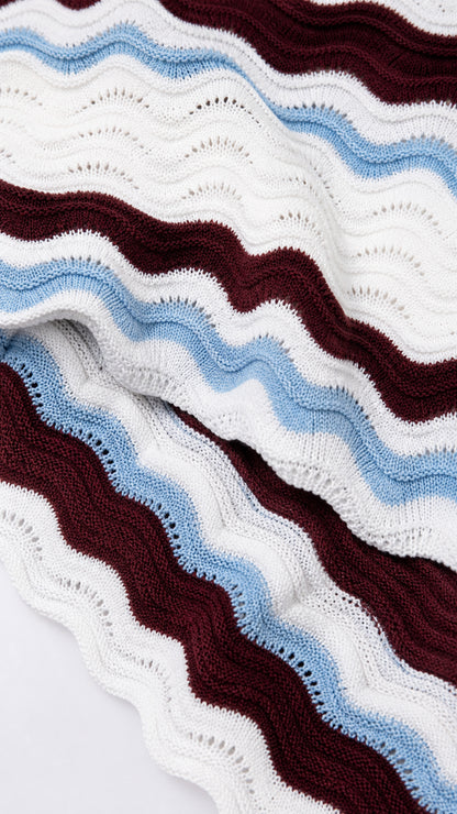 Close-up of wavy striped knit fabric in burgundy, blue, and white