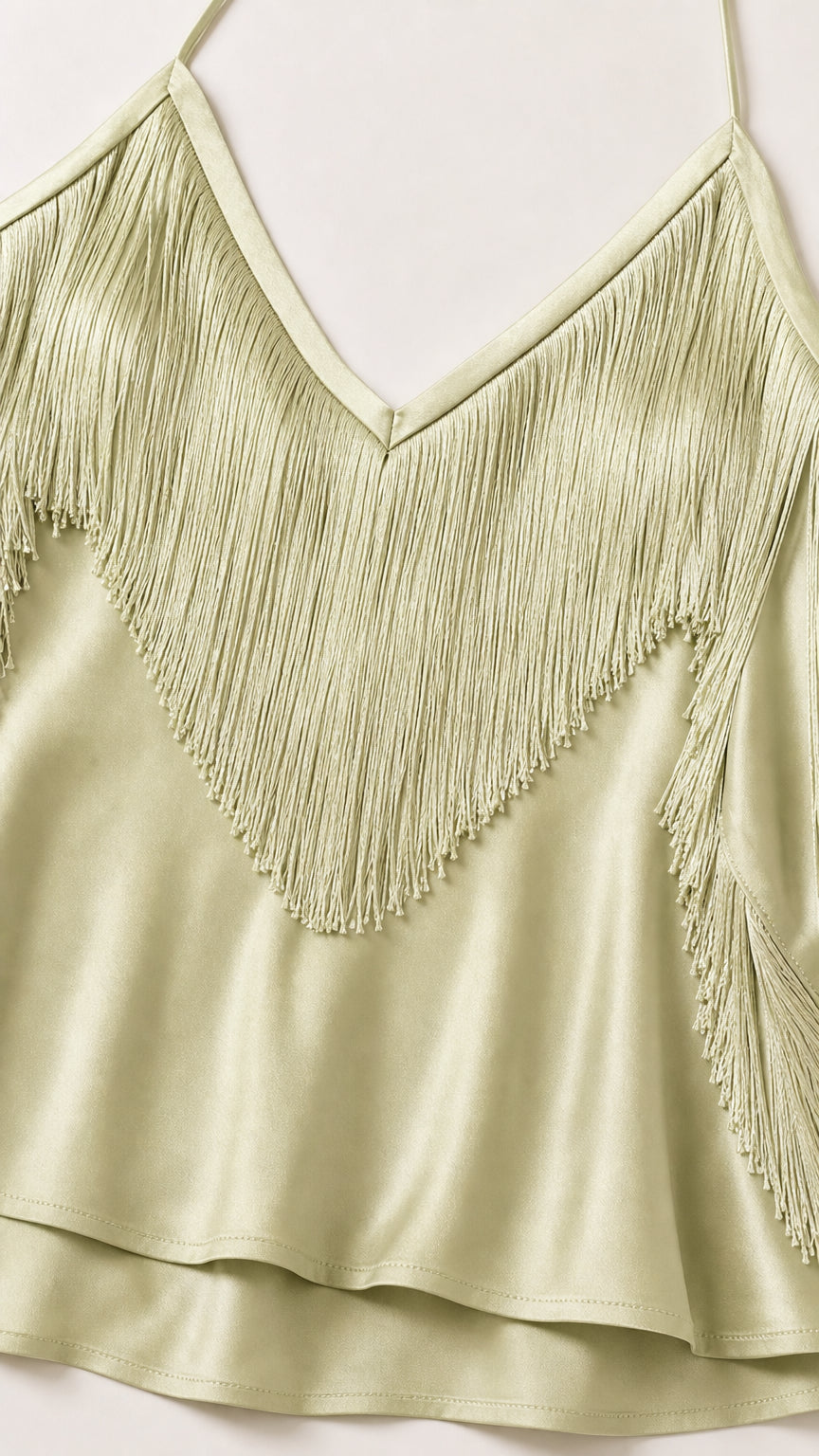 Close-up detail of sage green fringe bodice and satin hem