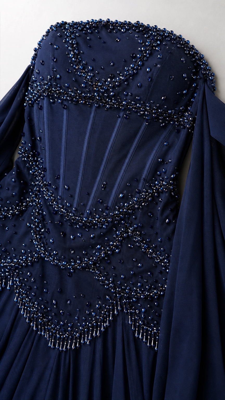Close-up of navy blue structured corset bodice with intricate beadwork and boning