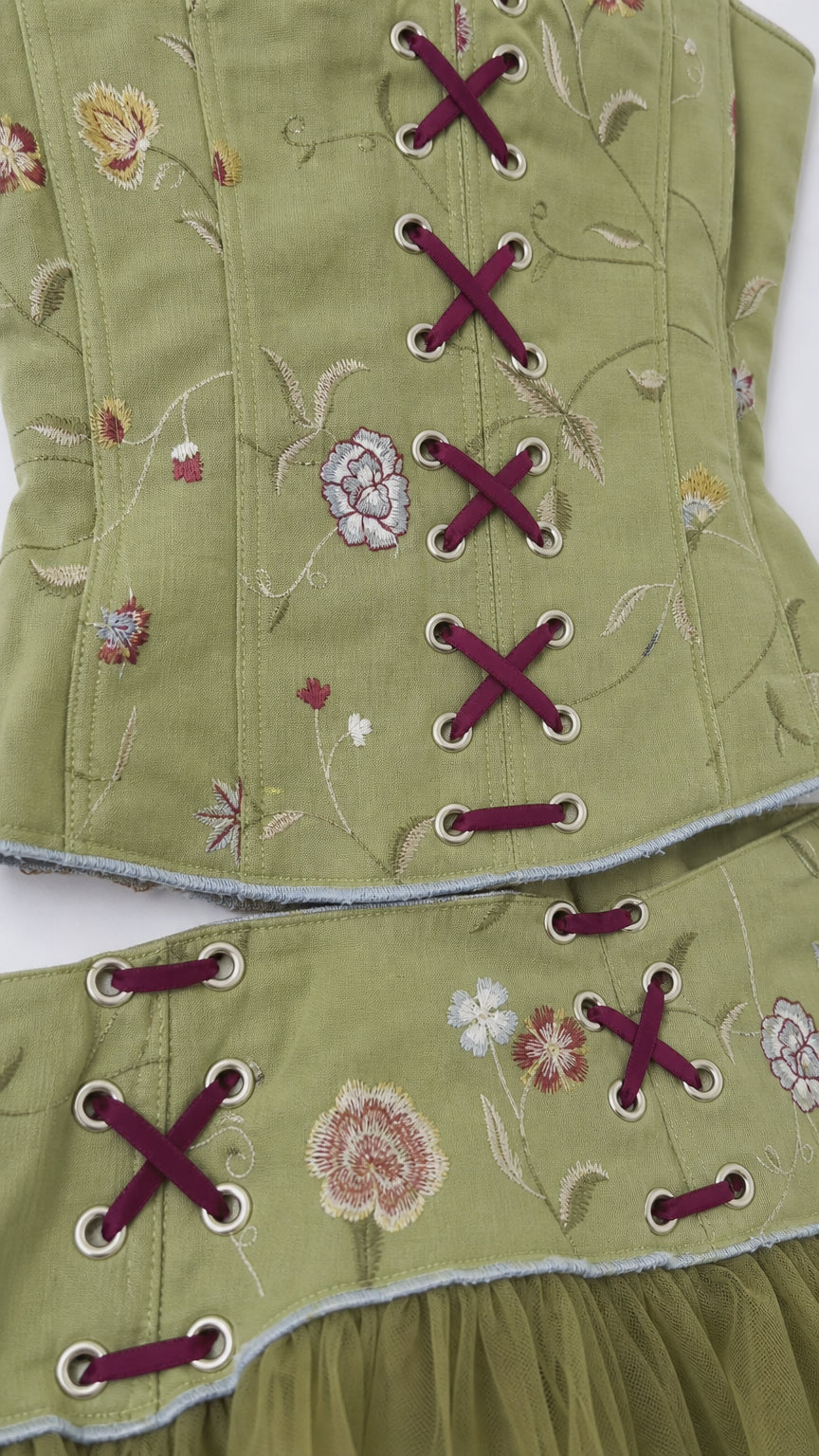 Close-up detail of floral embroidery and grommet lace-up styling