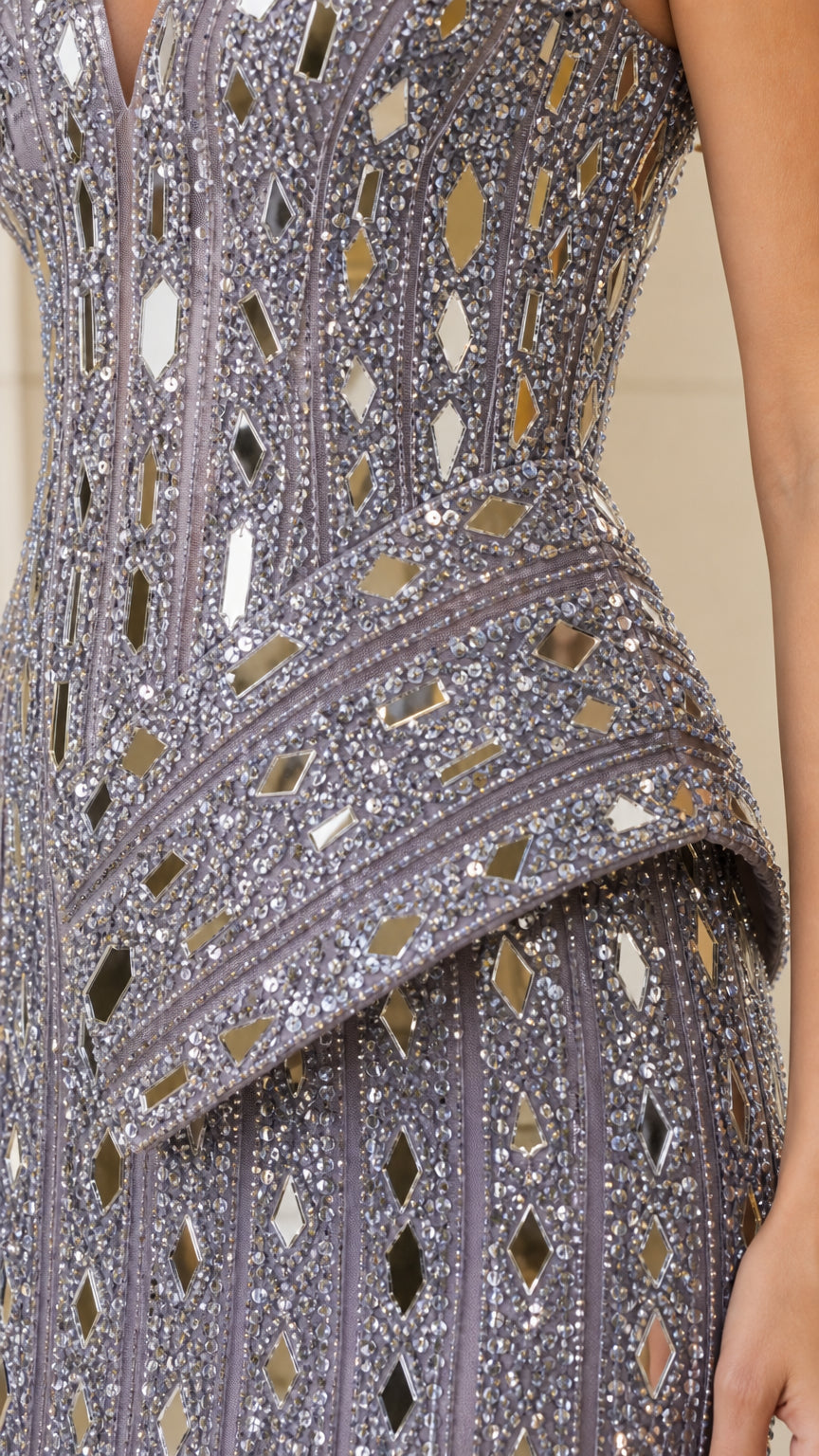 Close-up detail of geometric mirrored sequin and bead embellishments with asymmetrical peplum