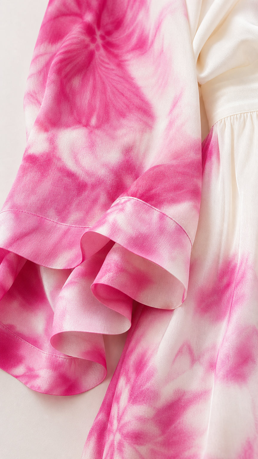 Close-up detail of smooth pink and white tie-dye fabric and sleeve hem