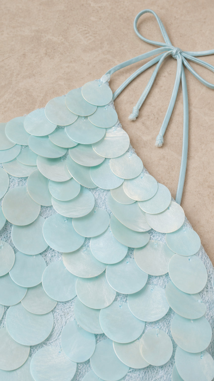 Close up of textured circular sequins and tie straps in Light Blue