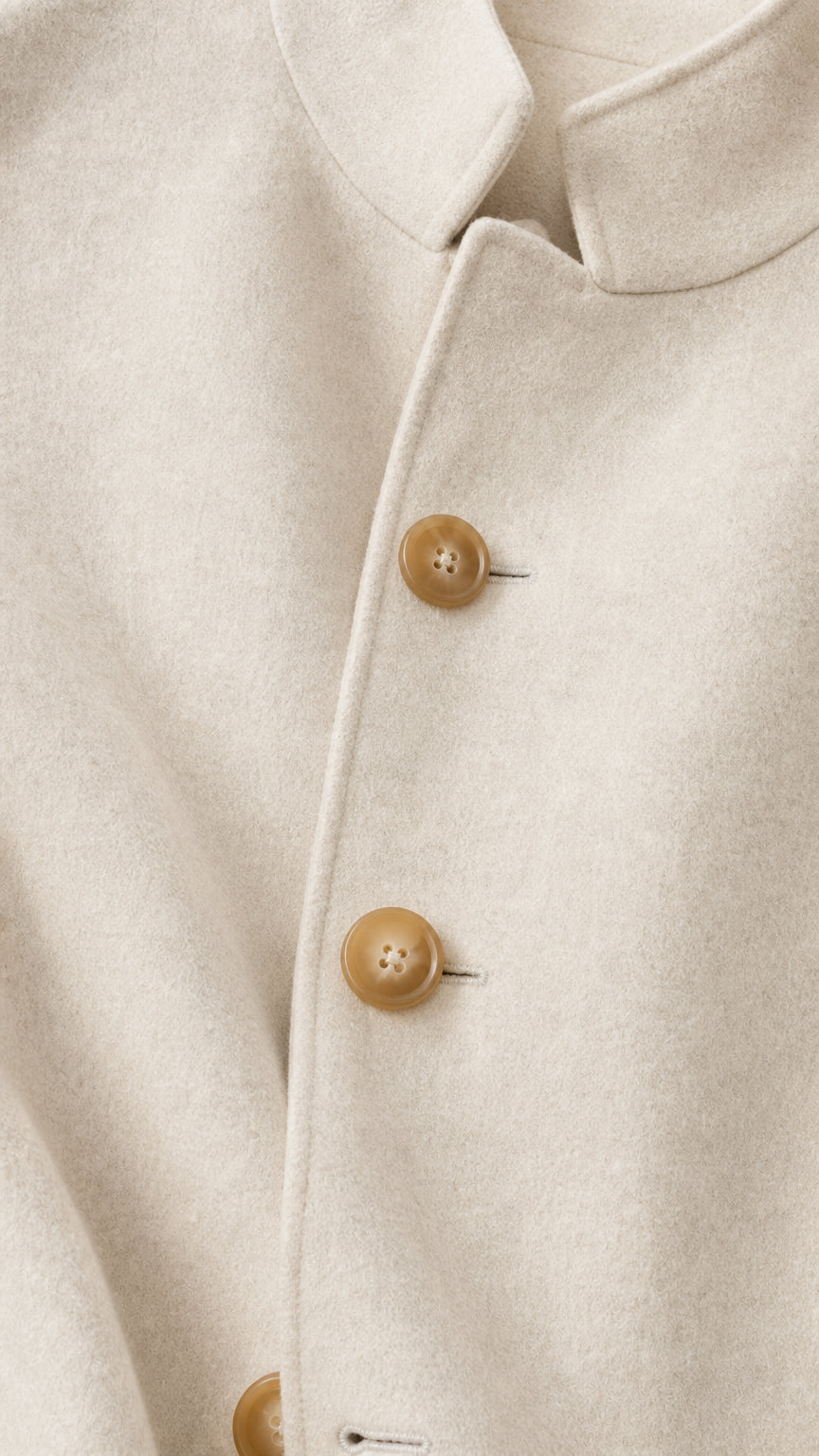 Close-up detail of cream stand collar and horn-style buttons