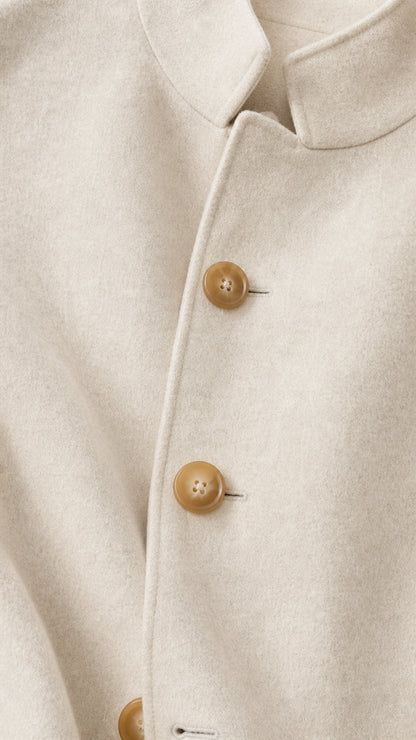 Close-up detail of cream stand collar and horn-style buttons