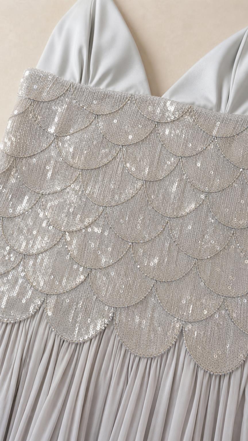 Close-up detail of scallop sequin bodice and pleated skirt