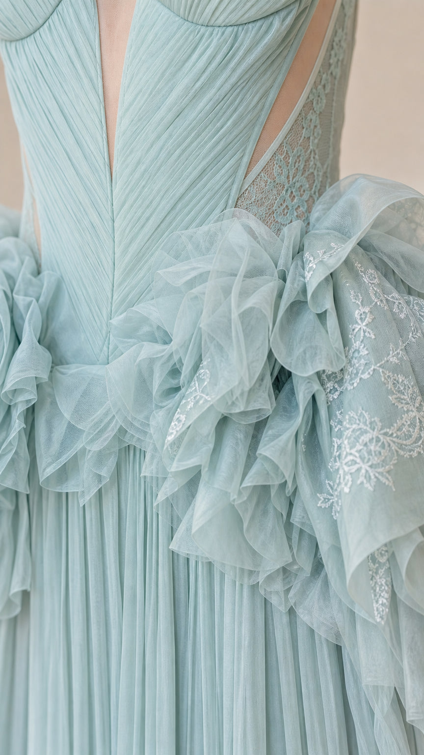 Close-up detail of sheer plunging bodice and embroidered ruffle waist