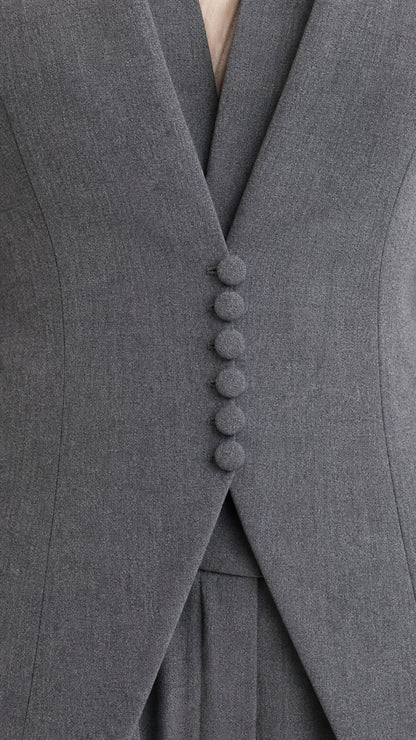 Close-up detail of grey blazer showcasing tonal covered buttons and elegant lapel tailoring