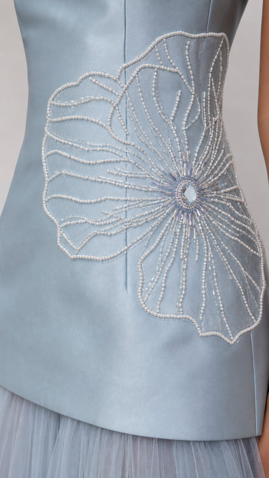 Close-up detail of pearl-tone beaded floral embellishment on satin bodice