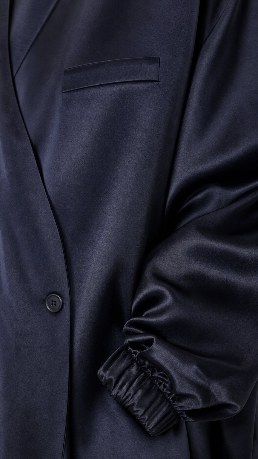Close-up of navy blue satin jacket details and elasticated gathered cuff