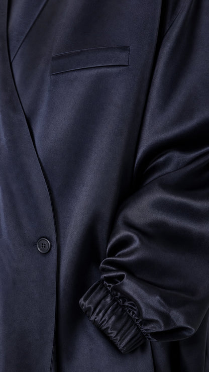 Close-up of navy blue satin jacket details and elasticated gathered cuff