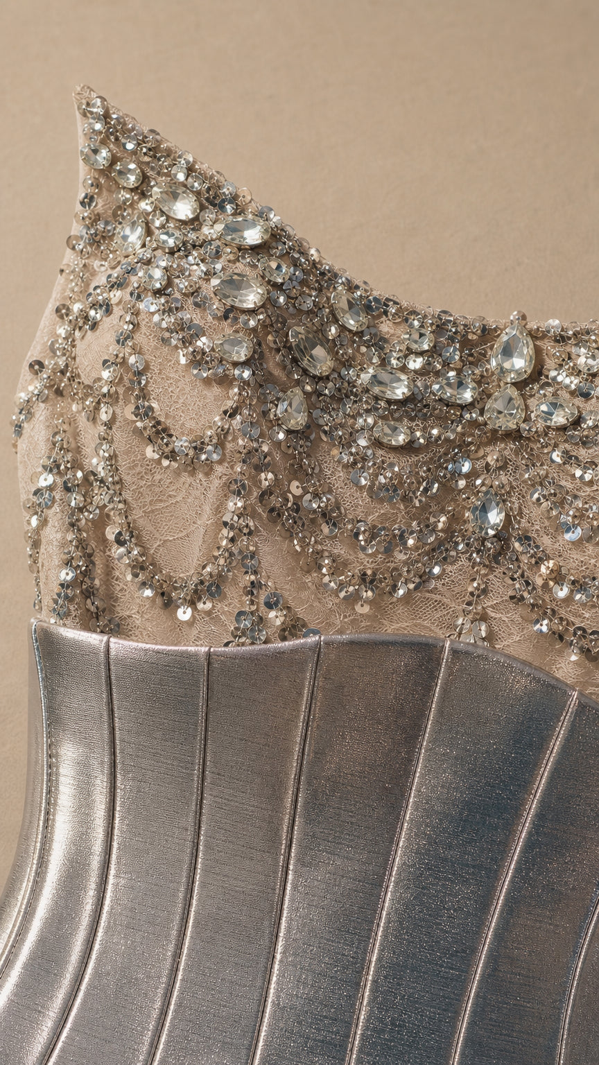 Close-up detail of silver crystal embellishments, beaded mesh, and metallic corset panel