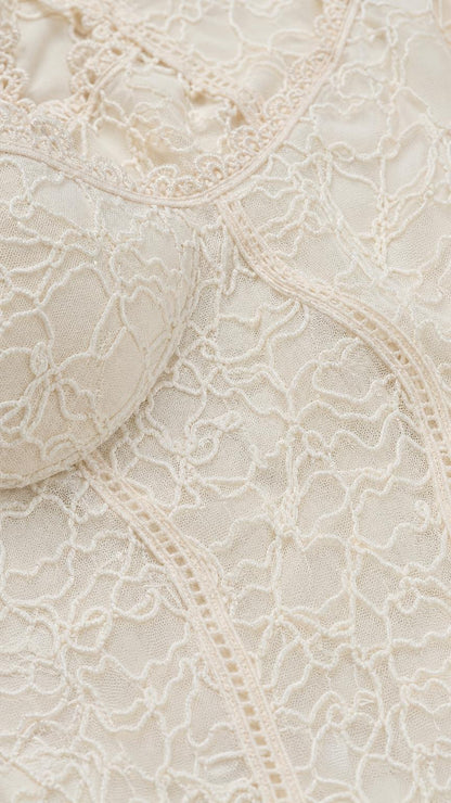 Close-up detail of textured lace fabric and scoop neckline