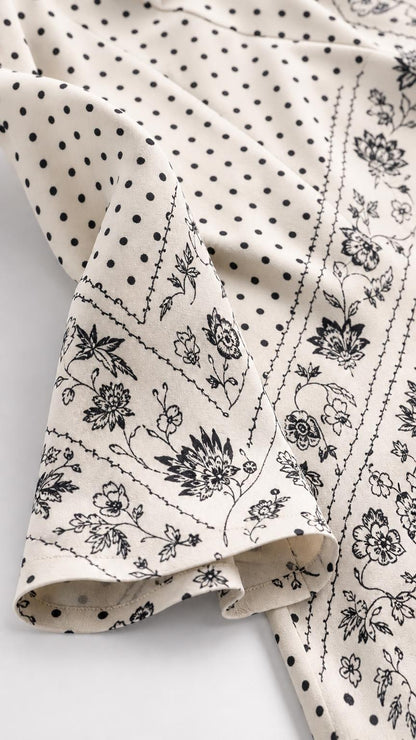 Close up fabric detail of cream dress with dot and floral pattern