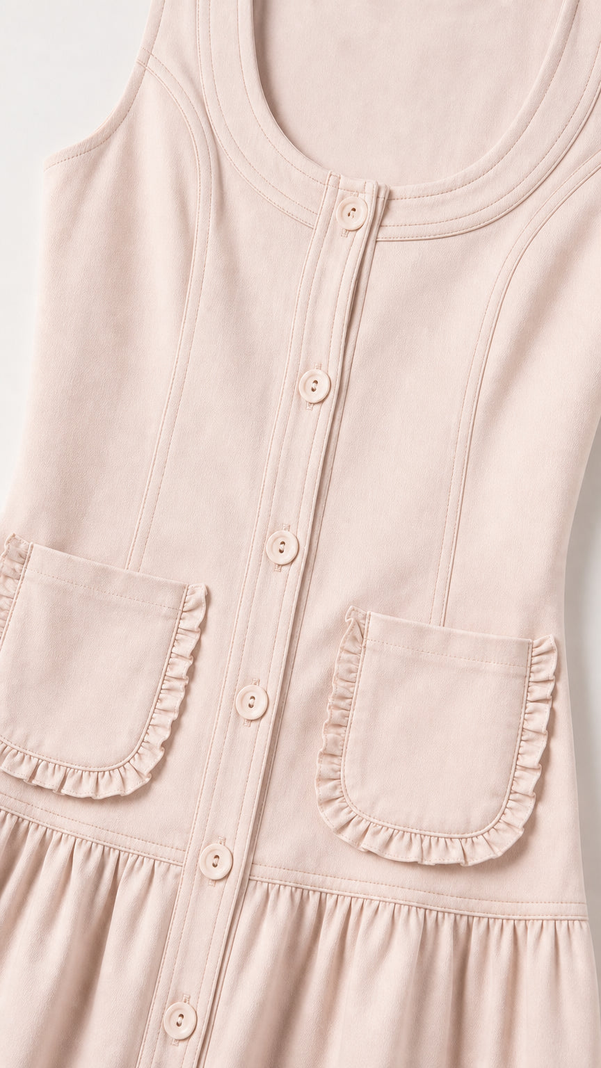 Close-up of pink midi dress showing button placket and ruffle pockets