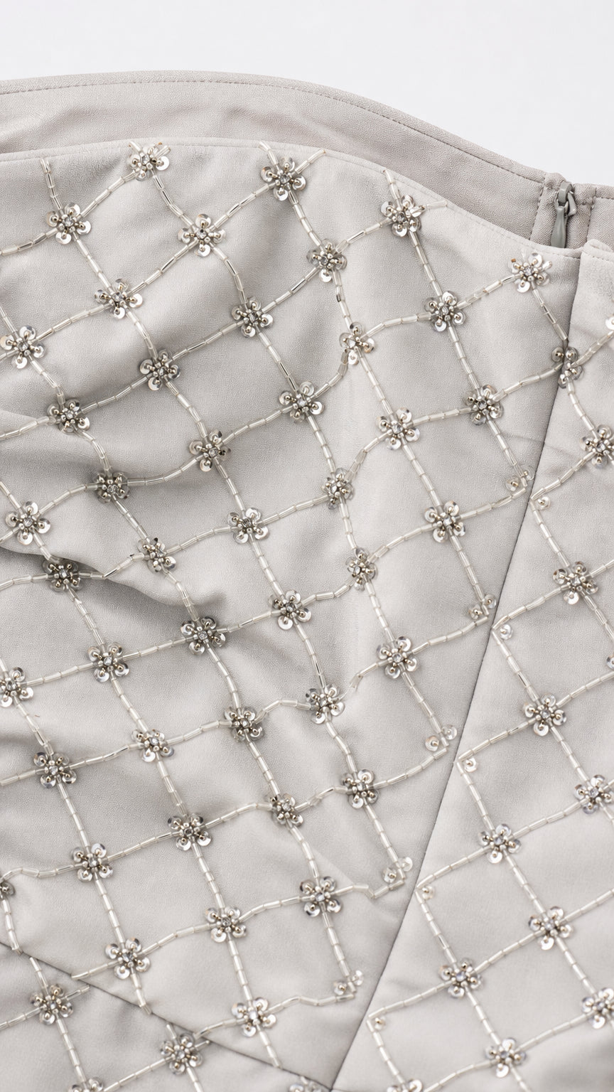 Close-up detail of silver beaded lattice pattern and fabric texture