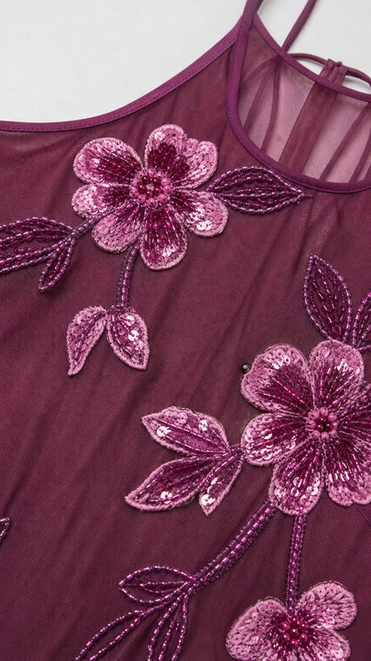 Close-up detail of floral embroidery and beading on mesh fabric