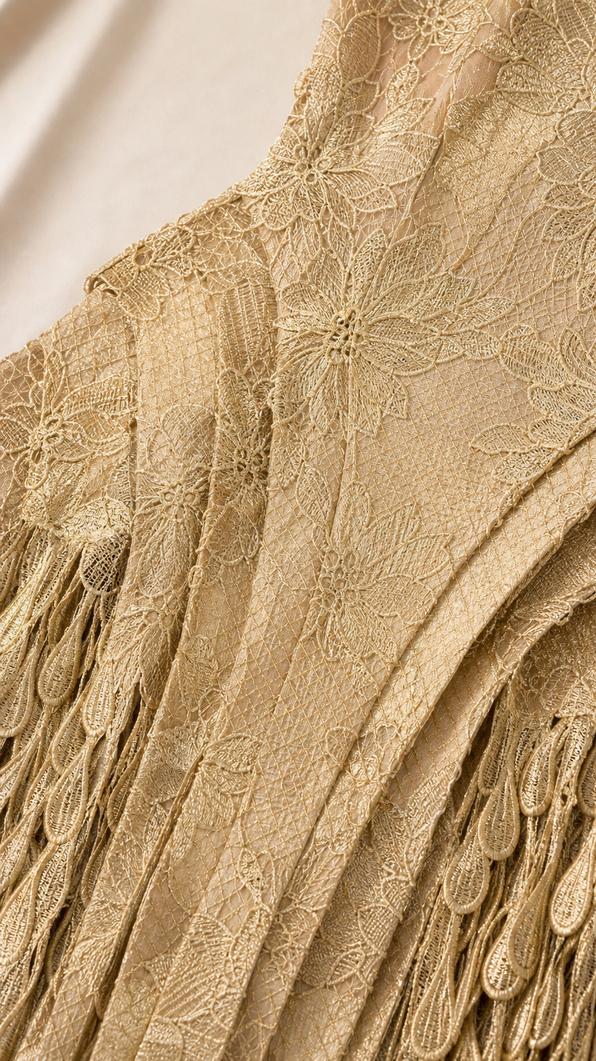 Close-up detail of textured floral lace fabric and scalloped hem